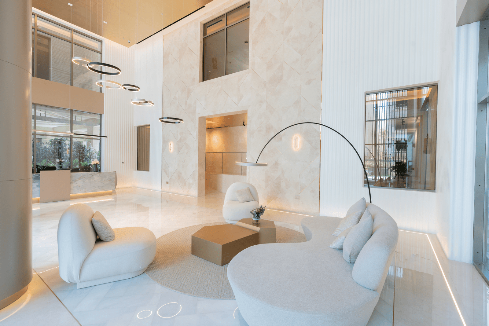 Elegant lobby with high ceilings, marble walls, and modern seating.